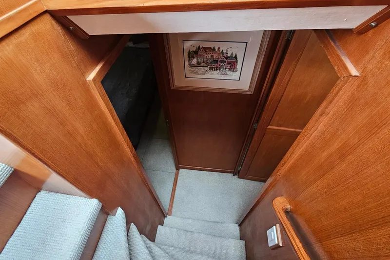  Yacht Photos Pics Interior of 1987 DeFever 53 POC yacht, featuring wooden stairs and cozy hallway.