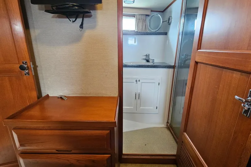  Yacht Photos Pics 1987 DeFever 53 POC yacht interior with wooden cabinetry and compact bathroom.
