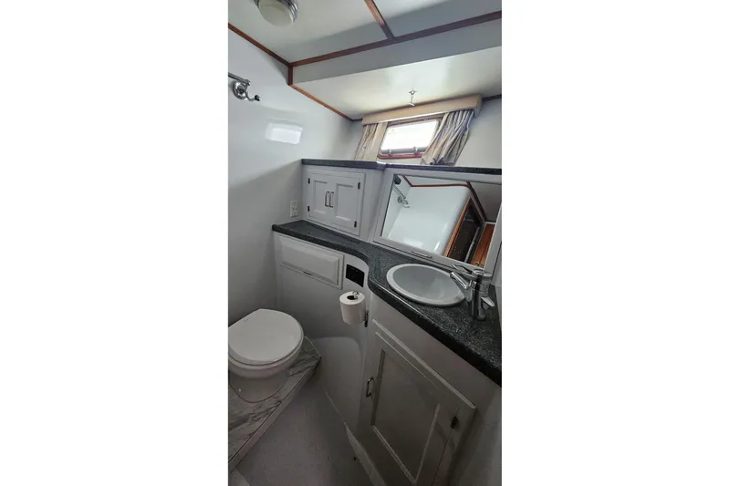  Yacht Photos Pics Bathroom interior of 1987 DeFever 53 POC yacht, featuring sink, toilet, and window.