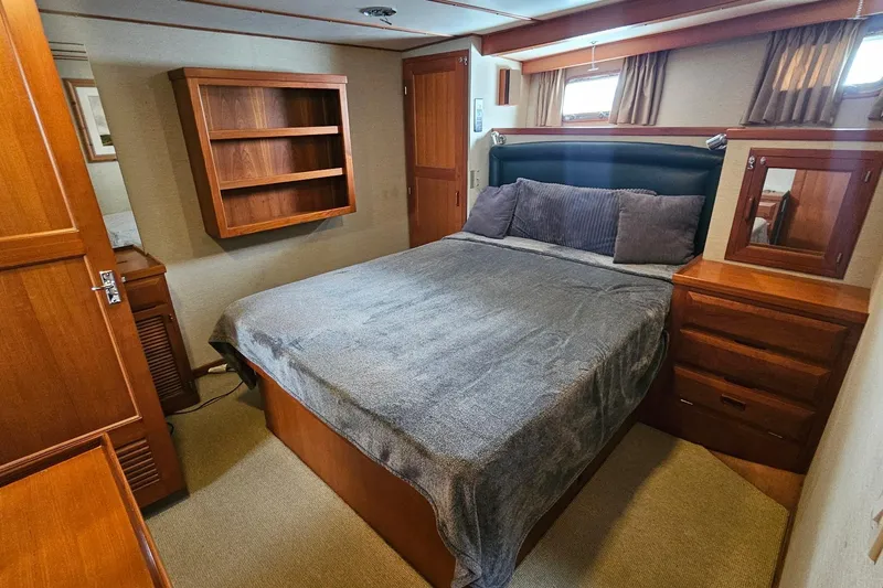  Yacht Photos Pics 1987 DeFever 53 POC yacht bedroom with wooden furnishings and cozy bedding.