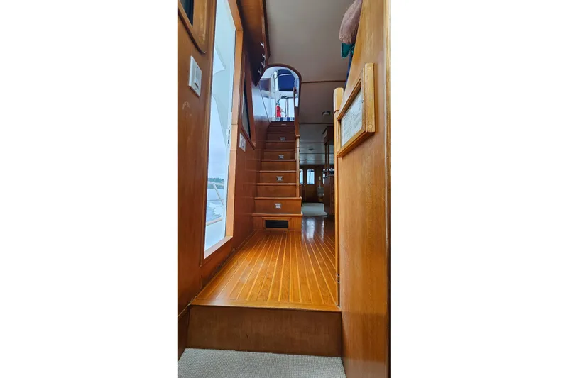  Yacht Photos Pics Interior view of 1987 DeFever 53 POC yacht, featuring wooden stairs and elegant design.