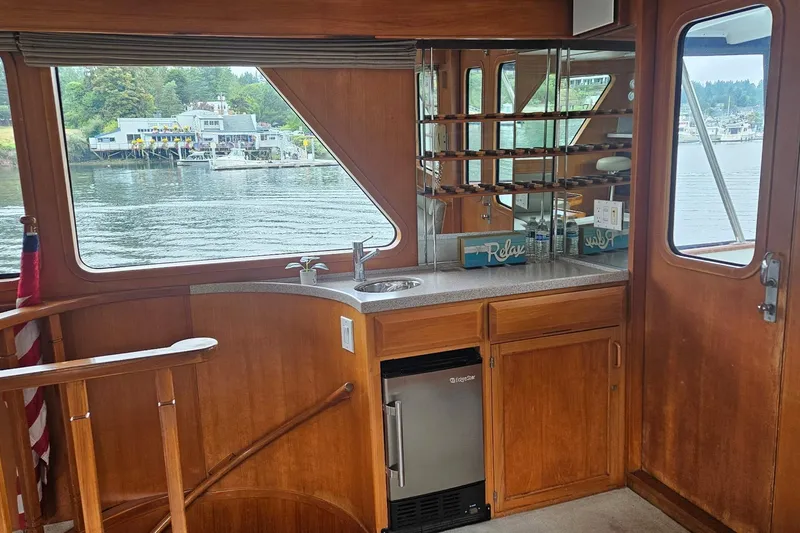  Yacht Photos Pics 1987 DeFever 53 POC yacht interior with kitchenette, wooden cabinetry, and waterfront view.