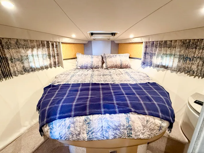 Formula 41pc Yacht Photos Pics Cozy bedroom in a 1999 Formula 41 PC yacht with patterned bedding and soft lighting.