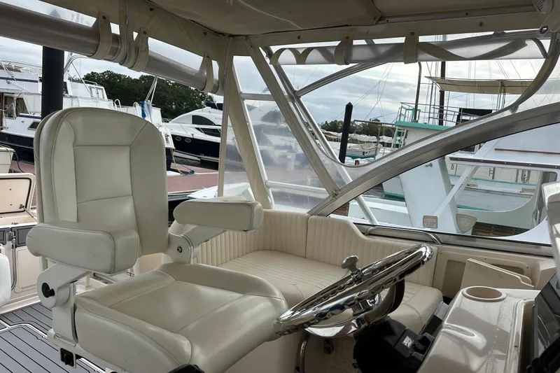 Triple Threat Yacht Photos Pics 2008 Grady-White Express 330 boat interior with white seating and steering wheel.