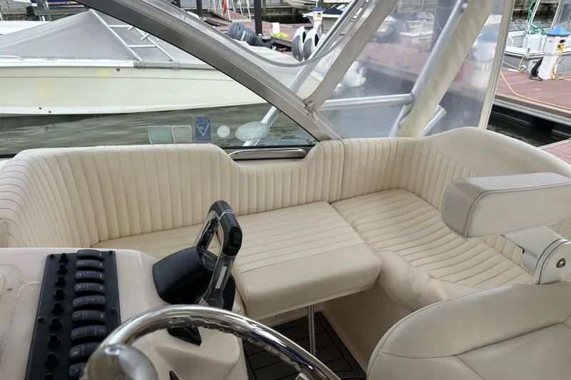 Triple Threat Yacht Photos Pics 2008 Grady-White Express 330 boat interior with beige seating and control panel.