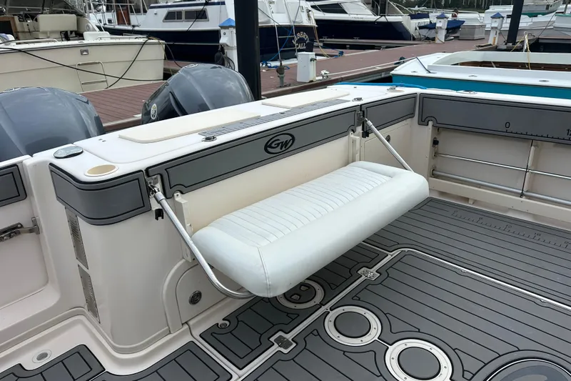 Triple Threat Yacht Photos Pics 2008 Grady-White Express 330 boat interior with foldable seat and dual engines at dock.