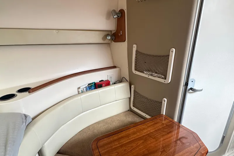 Triple Threat Yacht Photos Pics 2008 Grady-White Express 330 cabin interior with seating, table, and storage nets.