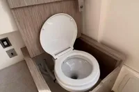 2023 Capelli Tempest 1000 Open boat toilet with wooden enclosure.