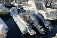 2023 Capelli Tempest 1000 Open boat docked in a marina, featuring dual outboard engines.