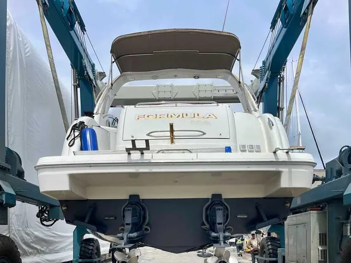 Yacht Photos Pics 2003 Formula 37 PC boat on lift, rear view, with blue fender and canopy.