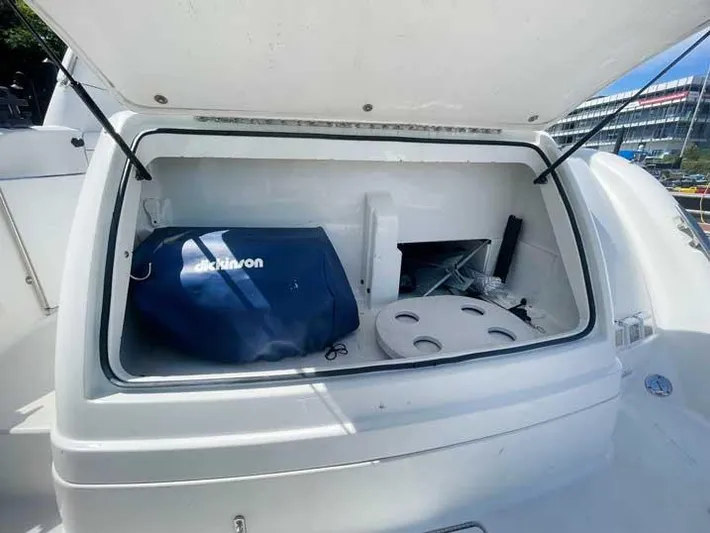  Yacht Photos Pics Open storage compartment on a 2003 Formula 37 PC boat, featuring a blue cover and accessories.