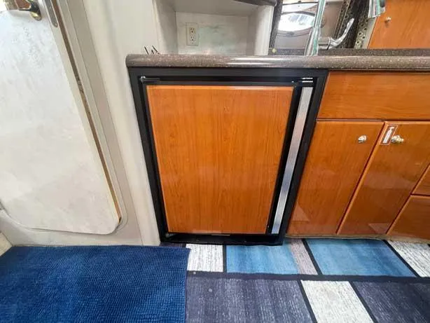  Yacht Photos Pics 2003 Formula 37 PC yacht interior with wooden cabinetry and compact refrigerator.