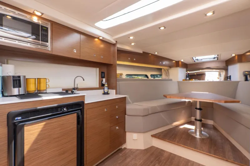  Yacht Photos Pics Luxurious interior of 2016 Cruisers Yachts 390 Express Coupe with modern kitchen and seating area.