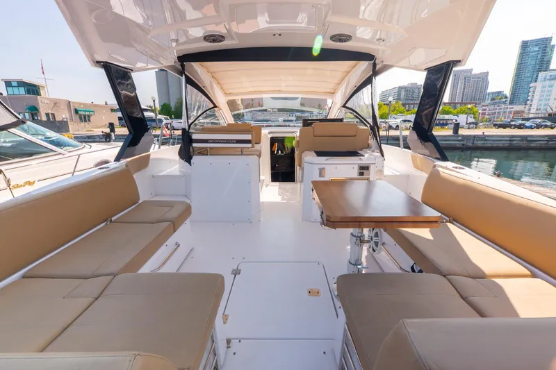  Yacht Photos Pics 2016 Cruisers Yachts 390 Express Coupe interior with beige seating and wooden table.