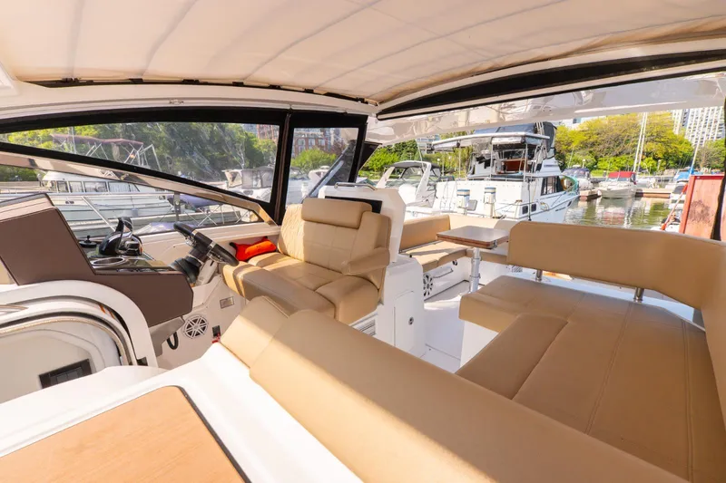  Yacht Photos Pics 2016 Cruisers Yachts 390 Express Coupe interior with beige seating, docked in a marina.