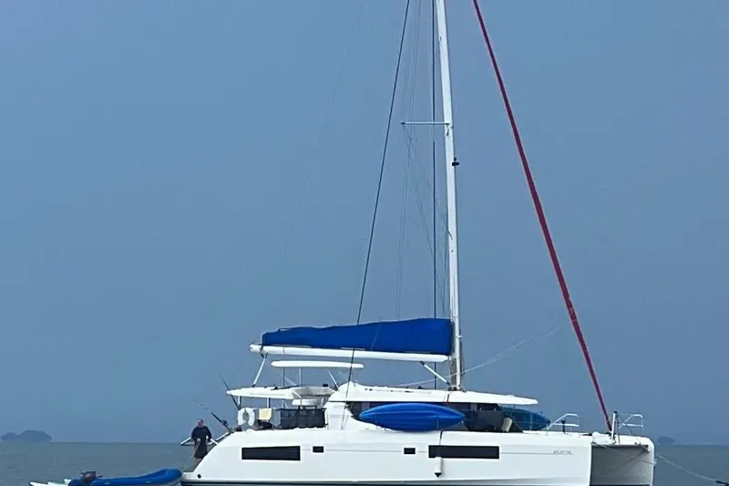 Nice Aft Too Yacht Photos Pics 2018 Leopard 45 catamaran with blue sail cover on calm water.