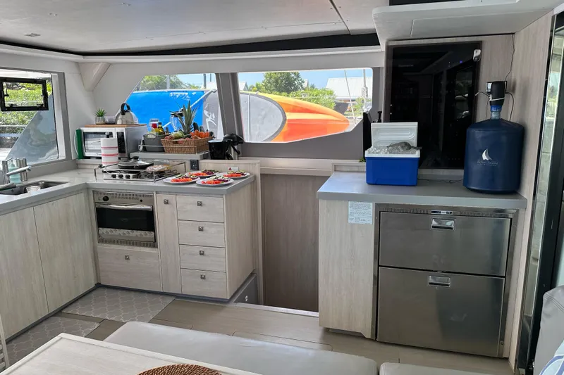 Nice Aft Too Yacht Photos Pics Modern kitchen interior on a 2018 Leopard 45 yacht, featuring appliances and fresh produce.