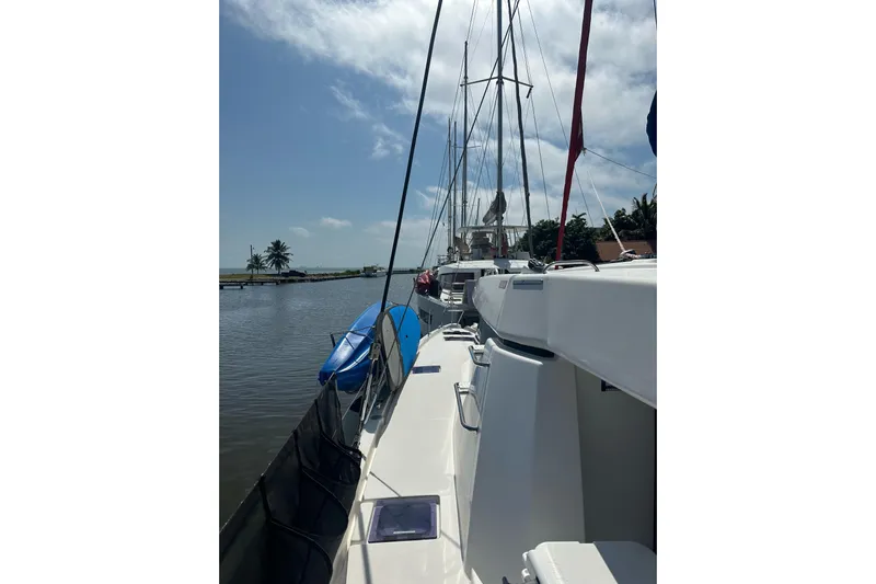 Nice Aft Too Yacht Photos Pics 2018 Leopard 45 catamaran docked by calm waters under a clear sky.