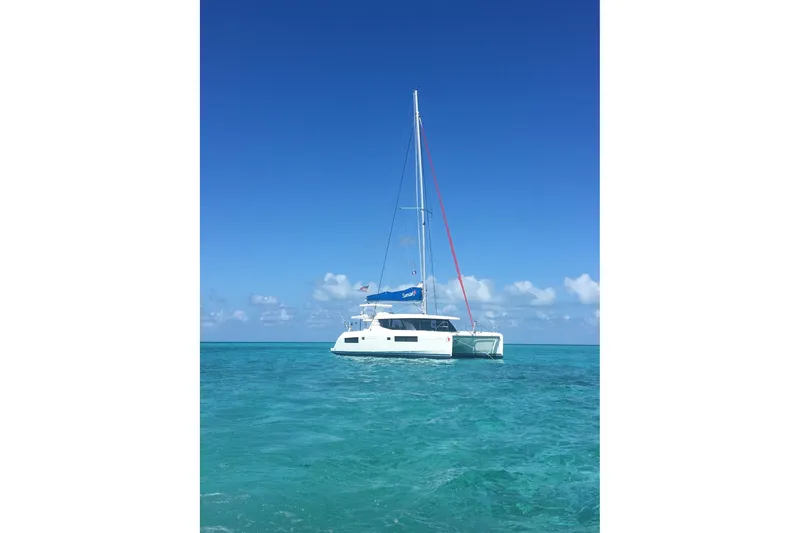 Nice Aft Too Yacht Photos Pics 2018 Leopard 45 catamaran sailing on clear turquoise waters under a bright blue sky.