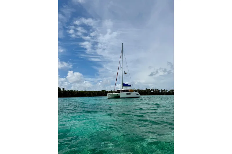 Nice Aft Too Yacht Photos Pics Sailing catamaran Leopard 45, 2018 model, anchored in turquoise waters under a blue sky.