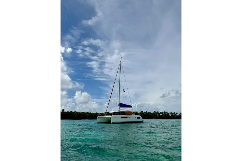 Nice Aft Too Yacht Photos Pics 2018 Leopard 45 catamaran sailing on turquoise waters under a partly cloudy sky.