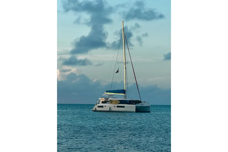 Nice Aft Too Yacht Photos Pics Sailing catamaran Leopard 45, 2018 model, anchored on calm ocean waters at sunset.