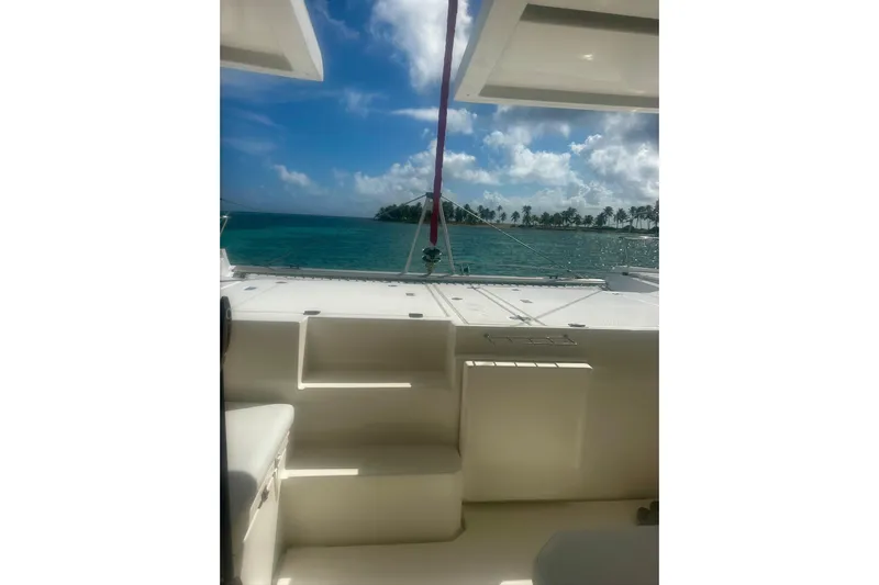 Nice Aft Too Yacht Photos Pics 2018 Leopard 45 catamaran interior with ocean view and tropical island in background.