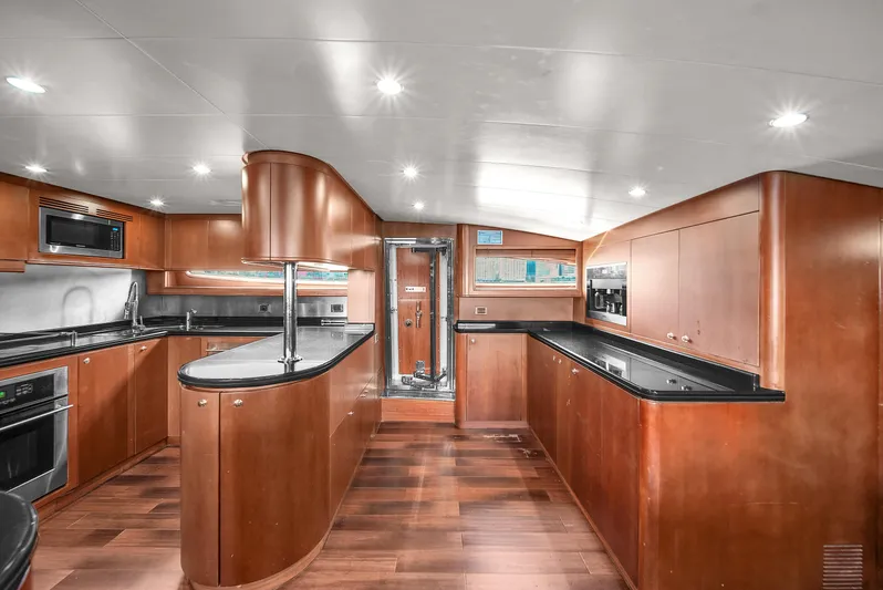  Yacht Photos Pics Luxurious kitchen interior of 2006 Azimut 100 Jumbo yacht with modern appliances and wooden cabinetry.