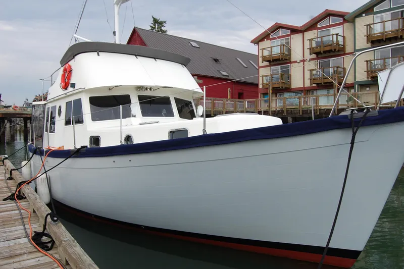  Yacht Photos Pics 1981 Willard Marine Pilot House Trawler docked near colorful waterfront buildings.