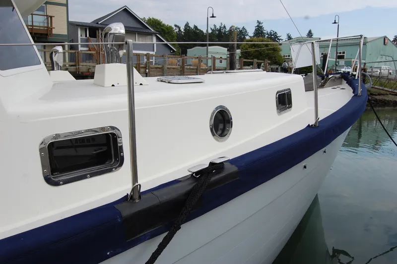  Yacht Photos Pics 1981 Willard Marine Pilot House Trawler docked, showcasing sleek white exterior and blue trim.