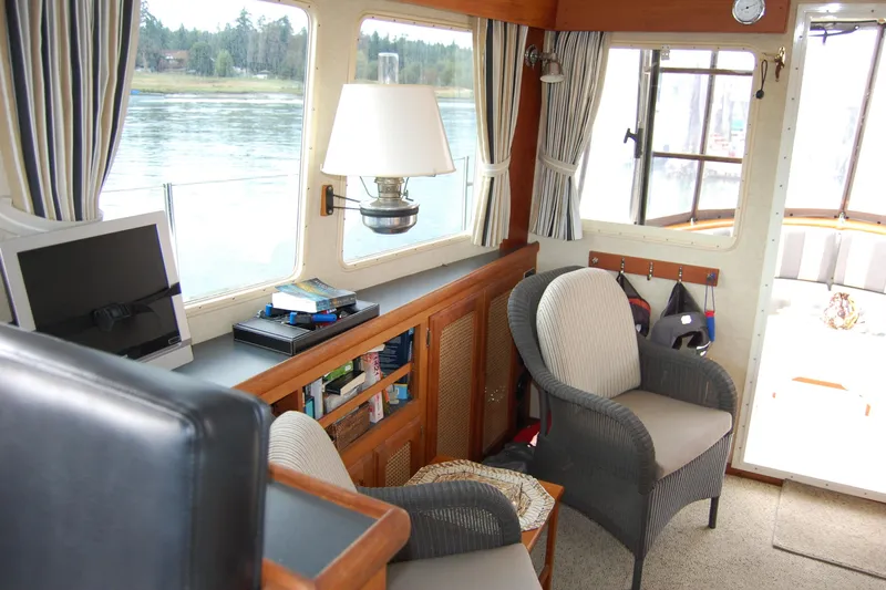  Yacht Photos Pics 1981 Willard Marine Pilot House Trawler interior with seating, books, and scenic window view.