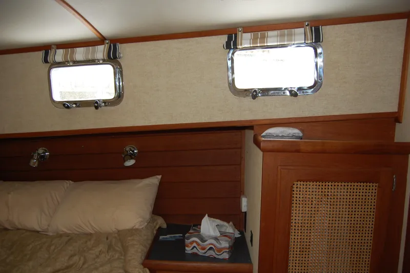  Yacht Photos Pics Cozy cabin interior of 1981 Willard Marine Pilot House Trawler with wooden accents and porthole windows.