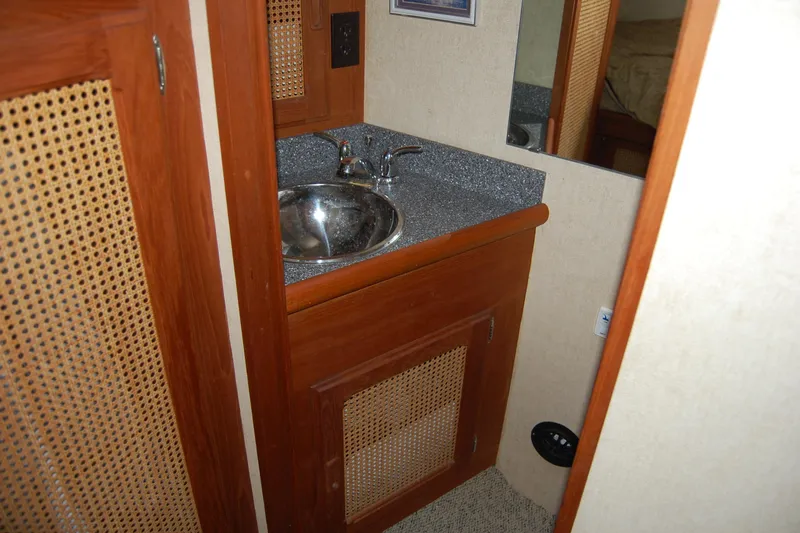  Yacht Photos Pics 1981 Willard Marine Pilot House Trawler bathroom with wooden cabinetry and stainless steel sink.