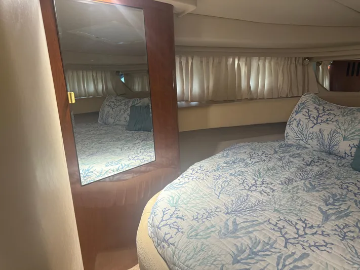  Yacht Photos Pics 2003 Sea Ray 380 Sundancer cabin with mirror, bed, and patterned bedding.