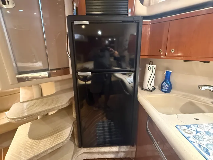  Yacht Photos Pics Interior of 2003 Sea Ray 380 Sundancer yacht with kitchenette and black refrigerator.