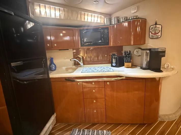  Yacht Photos Pics 2003 Sea Ray 380 Sundancer kitchen with wood cabinets, appliances, and countertop.