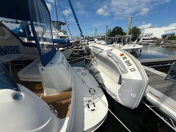  Yacht Photos Pics 2003 Sea Ray 380 Sundancer docked with inflatable boat, under clear blue sky.