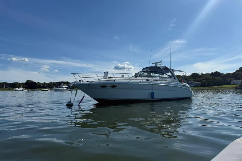  Yacht Photos Pics 2003 Sea Ray 380 Sundancer yacht anchored on calm water under a clear blue sky.