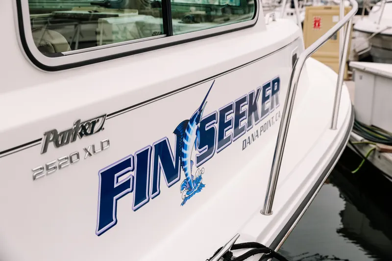  Yacht Photos Pics 2017 Parker 2520 XLD Sport Cabin boat with "Fin Seeker" logo at dock.