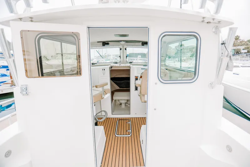  Yacht Photos Pics 2017 Parker 2520 XLD Sport Cabin interior with wooden flooring and seating.