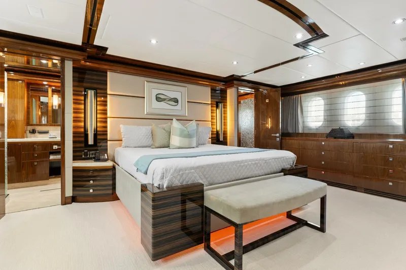 Mesmerize Yacht Photos Pics Luxurious bedroom interior of 2013 Hargrave 125 Raised Pilothouse yacht, featuring elegant wood finishes.