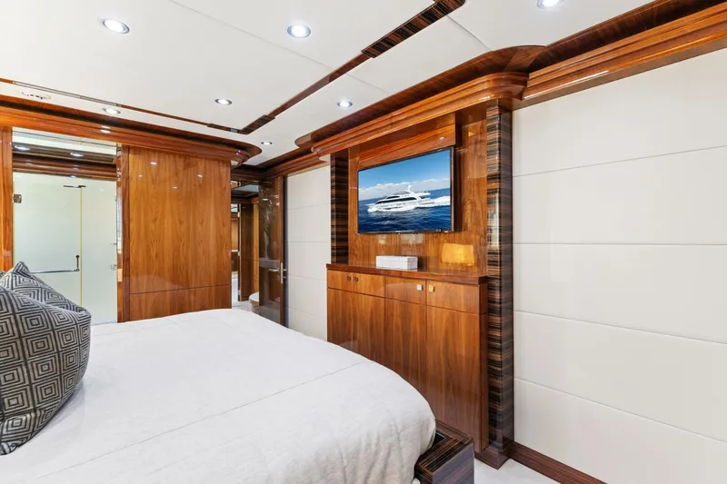 Mesmerize Yacht Photos Pics Luxurious bedroom interior of 2013 Hargrave 125 Raised Pilothouse yacht with wood paneling and TV.