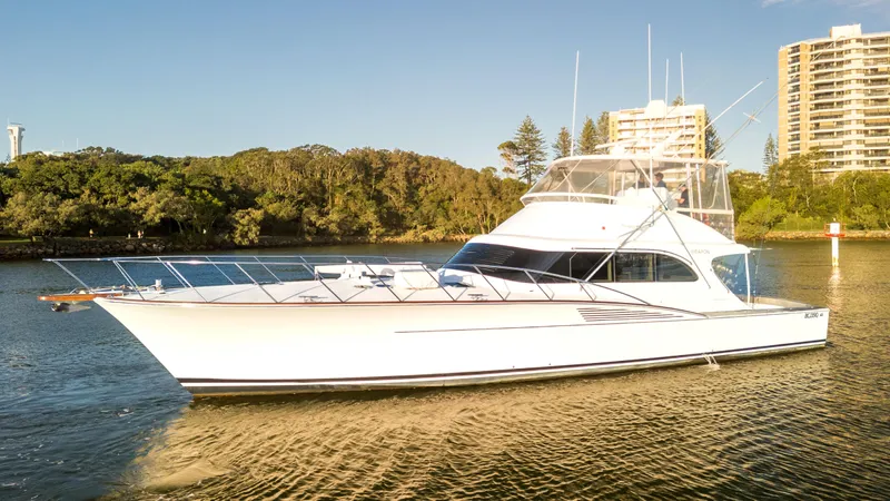 Weapon Yacht Photos Pics 1999 Norman Wright 63 Sport Fisher yacht on calm water near shoreline and buildings.