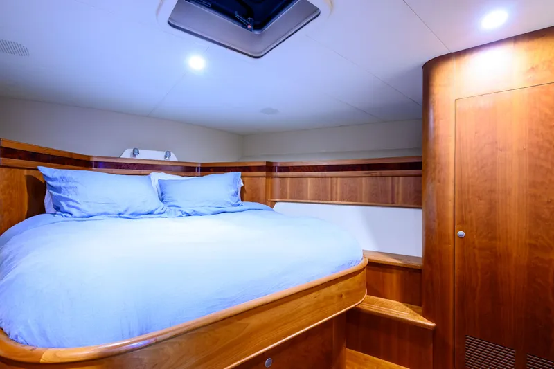 Weapon Yacht Photos Pics Luxurious cabin interior of 1999 Norman Wright 63 Sport Fisher with wooden finish and cozy bedding.