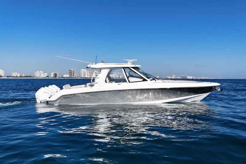 True Story Yacht Photos Pics 2022 Boston Whaler 380 Realm cruising on blue ocean near city skyline.