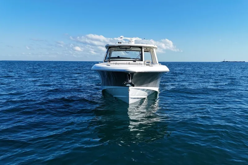 True Story Yacht Photos Pics 2022 Boston Whaler 380 Realm boat on open sea under clear blue sky.