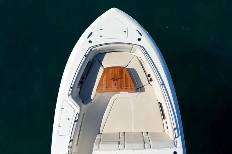 True Story Yacht Photos Pics Top view of 2022 Boston Whaler 380 Realm boat's bow seating area with wooden table.