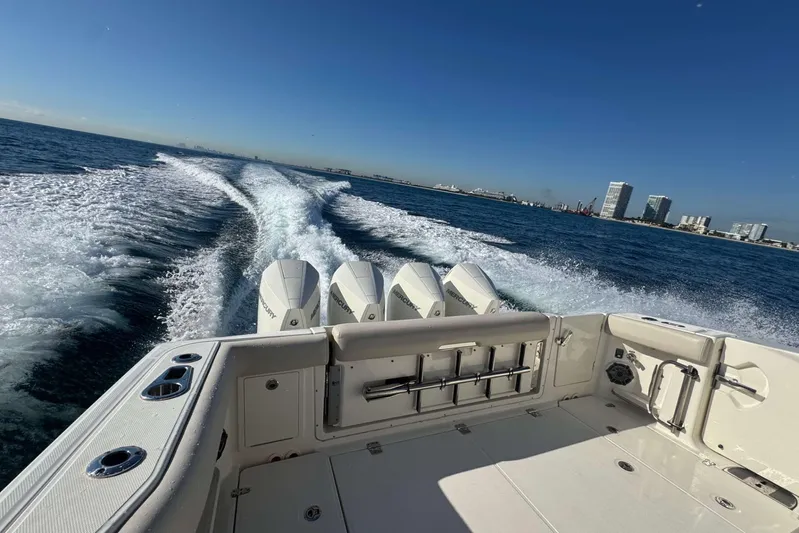 True Story Yacht Photos Pics 2022 Boston Whaler 380 Realm cruising on open water with city skyline in background.