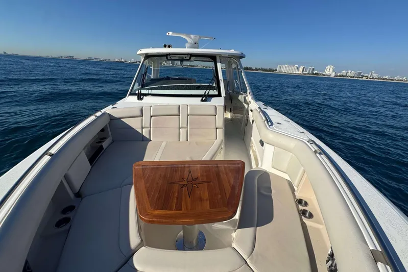 True Story Yacht Photos Pics 2022 Boston Whaler 380 Realm boat on open water, featuring spacious seating and wooden table.