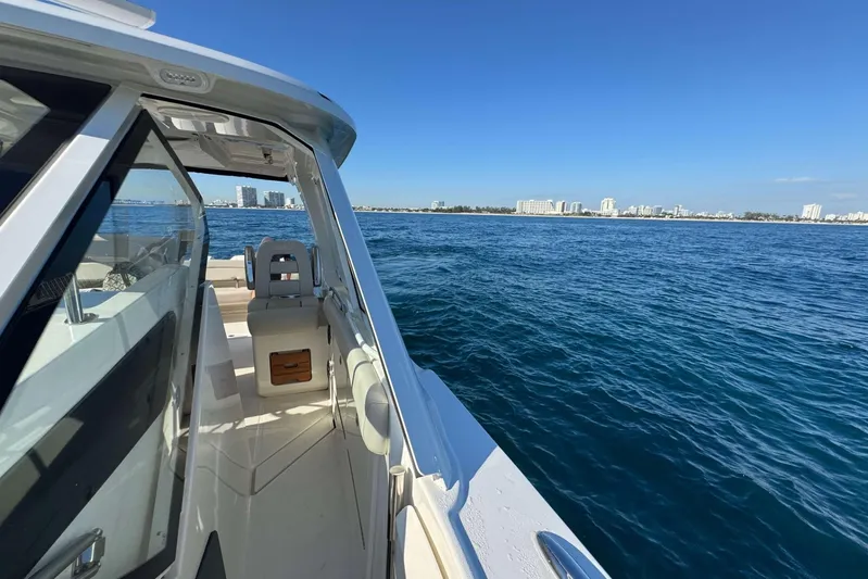 True Story Yacht Photos Pics 2022 Boston Whaler 380 Realm cruising on open water with city skyline in background.
